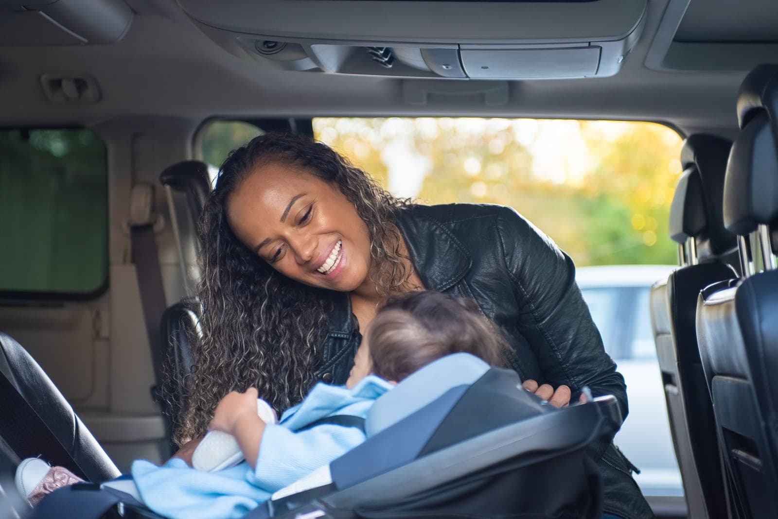 A child secured in a car seat in the back of a vehicle
